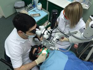 Врач-стоматолог Центра "Диал-Дент" Акопов Р.А. проводит лечение зуба с микроскопом